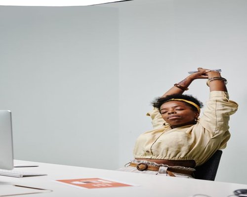 Person doing a light stretch while sitting at a home office desk